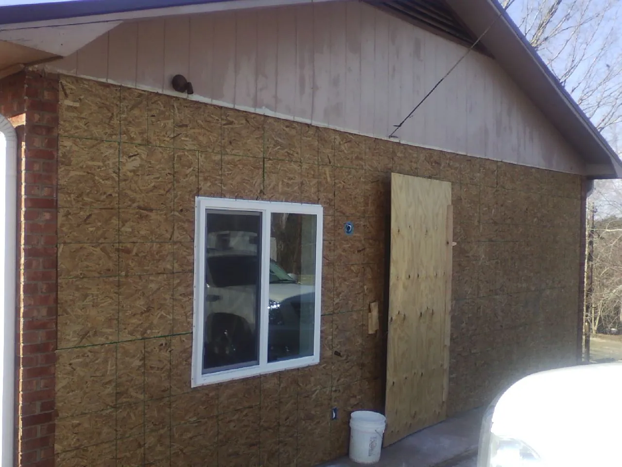 OSB sheathing on a garage addition wall before siding in Amityville