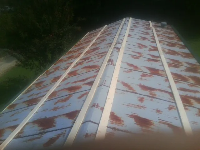 Rusted metal roof panels with new wood purlins before replacement — Storm Damage Roof Repair in Amityville by Roofing Brothers