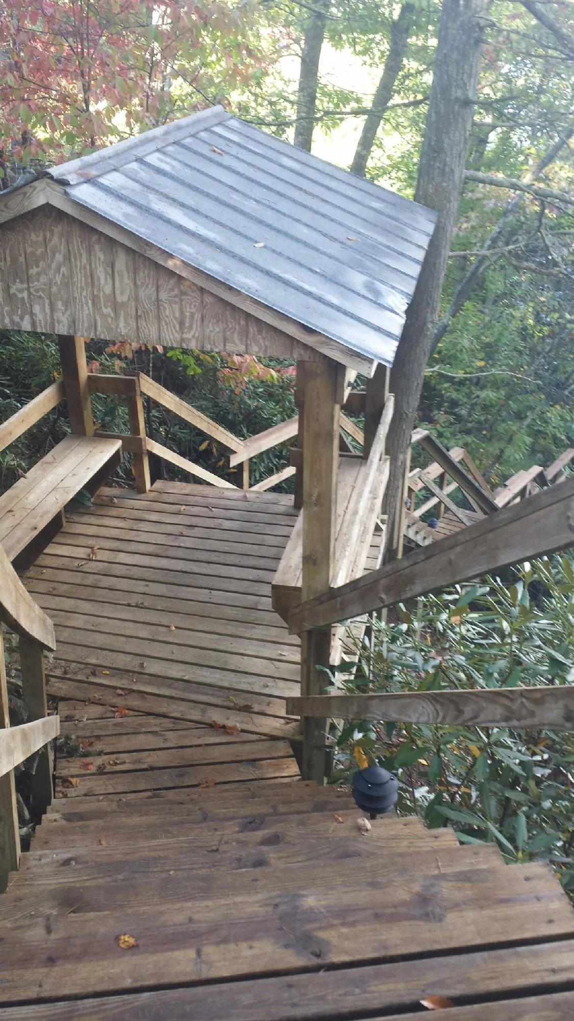 Metal roofed shelter over wooden steps on a wooded walkway — Skylight Repair & Installation work by our crew in Amityville