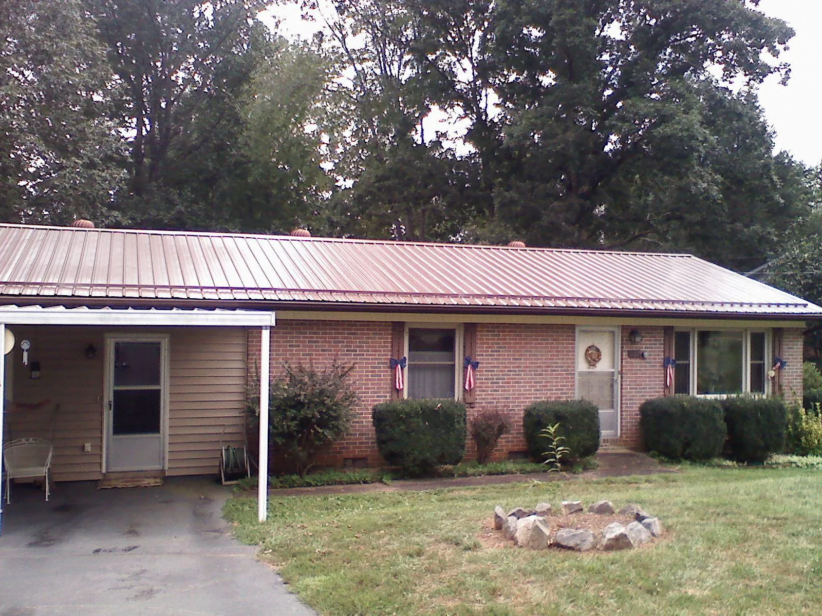 Bronze metal roof and carport on a brick ranch home — Roof Repair work by our crew in Amityville